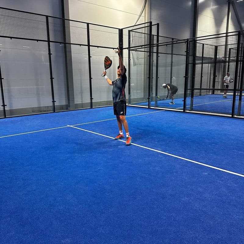 John spelar padel på en inomhusbana